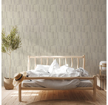 Schlafzimmer mit Bett vor einer Wand mit gemusterter Tapete und einer Topfpflanze.