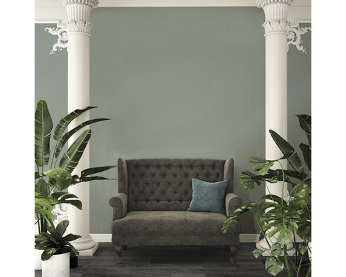 Interieuransicht mit Sofa, Kissen, Säulen und Pflanzen.