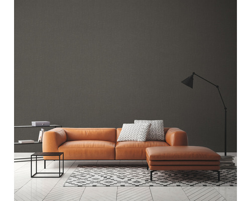 Modernes Wohnzimmer mit braunem Sofa, Teppich mit geometrischem Muster und Stehlampe.