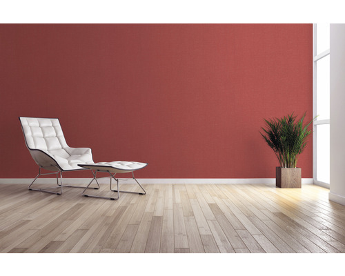 Wohnzimmer mit Sessel, Fußhocker, Zimmerpflanze und Wandgestaltung