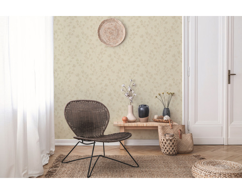 Wohnraum mit gemusterter Tapete, geflochtenem Stuhl und dekorativen Elementen für ein gemütliches Ambiente.