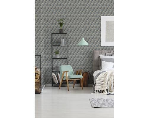 Schlafzimmer mit Bett, Sessel, Regal und Tapete mit geometrischem Muster