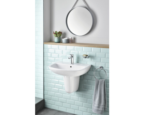 Salle de bain lumineuse avec vasque, robinet, porte-serviettes, miroir et étagère