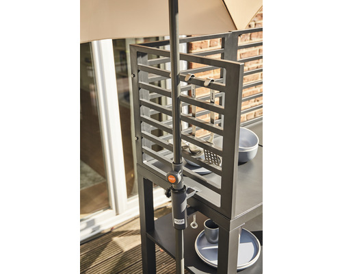 Vue détaillée d''une cuisine d''extérieur avec des étagères, des ustensiles de cuisine et un support de parasol.