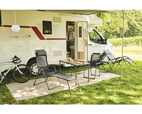 Campingplatzszene mit Wohnwagen, Tisch, Stühlen, Liegestuhl und Fahrrad