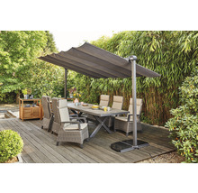 Scène de jardin avec table à manger, chaises et parasol sur une terrasse.