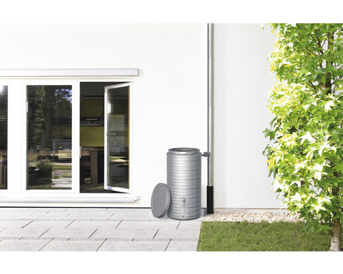 Récupérateur d''eau de pluie à côté du mur de la maison avec descente pluviale et fenêtre ouverte