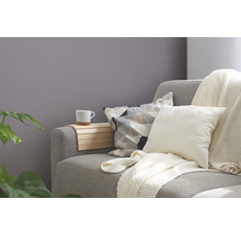 Graues Sofa mit Kissen, Überwurf und Ablage mit Tasse