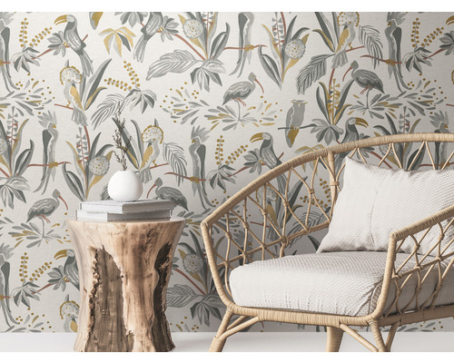 Szene mit einer Rattan-Sesselgarnitur vor einer Wandtapete mit Vogelmotiven