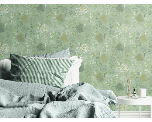 Schlafzimmer mit Blumentapete, Bett und Beistelltisch.