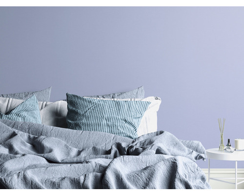 Schlafzimmer mit Bett, Kissen und Beistelltisch