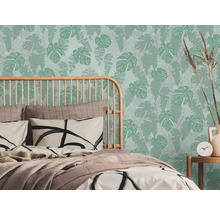 Schlafzimmer mit Bett und tropischer Blättertapete