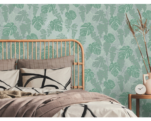 Chambre avec lit et papier peint à feuilles tropicales