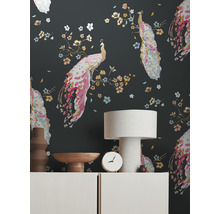 Salon avec un papier peint à motifs de paons, une lampe de table et des objets décoratifs sur un buffet.