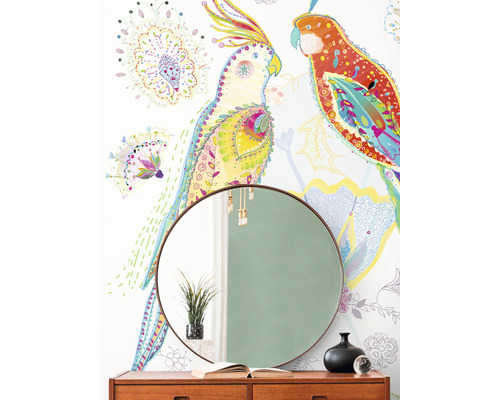 Wohnraum mit gemusterter Tapete, rundem Spiegel und Holzkommode