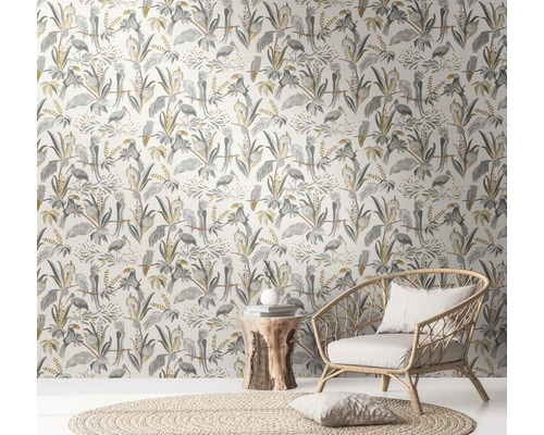 Raum mit Dschungeltapete mit Vögeln und Pflanzen, Korbsessel und Beistelltisch aus Holz