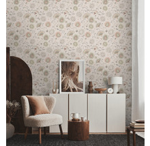 Salon lumineux avec papier peint à motifs floraux, fauteuil et commode