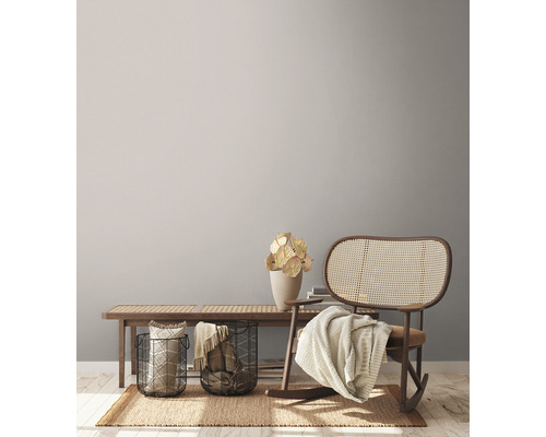 Wohnzimmer Szene mit Holzbank, Metallkörben, Dekorationen, Teppich und Schaukelstuhl.