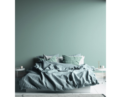 Schlafzimmer mit Bett, Kissen und Nachttischen.