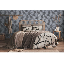 Ein Schlafzimmer mit einem Bett, einer Wand mit Blättermuster und dekorativen Elementen.