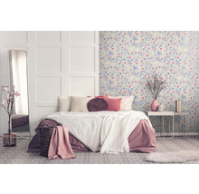 Helles Schlafzimmer mit Bett, Nachttisch und blumiger Tapete