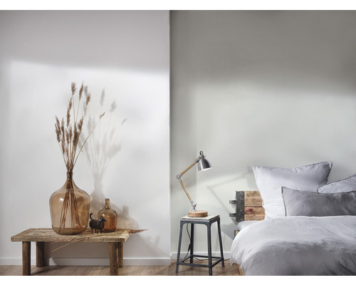 Aménagement de chambre clair et décoratif avec grande bonbonne en verre, lampe de table et lit