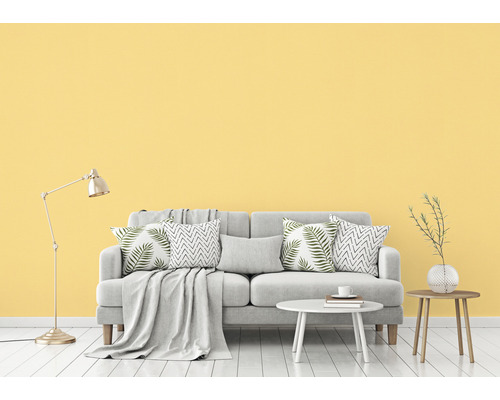 Helles Wohnzimmer mit Sofa, Kissen, Tisch und Stehlampe