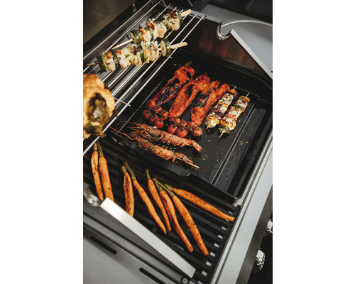 Gemüse und Spieße auf einem Grill.