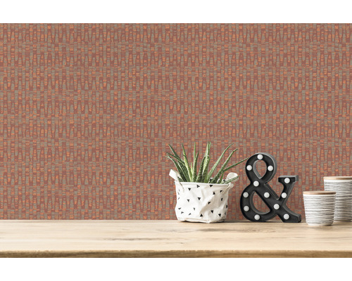 Nahaufnahme einer Wand mit einer Tapete mit geradlinigem Muster, dekoriert mit einer Zimmerpflanze, einer leuchtenden Ampersandfigur und zwei Bechern auf einer Holzfläche.