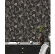 Wandgestaltung mit Tapete in abstraktem Design und dunklen Farbtönen hinter Kommode