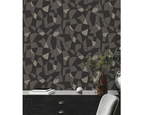Wandgestaltung mit Tapete in abstraktem Design und dunklen Farbtönen hinter Kommode