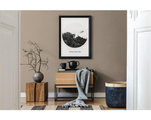 Dekoratives Zimmer mit Kommode, gerahmtem Bild, Korb und Holzhocker.