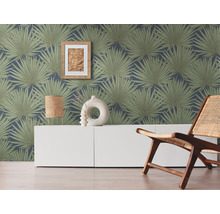 Wohnraum mit einer Wandtapete mit Palmenmuster, einem weißen Sideboard und einem Holzstuhl