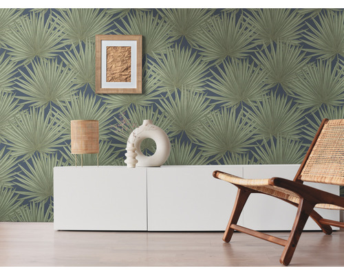 Wohnraum mit einer Wandtapete mit Palmenmuster, einem weißen Sideboard und einem Holzstuhl