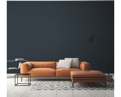 Wohnzimmer mit orangefarbenem Ledersofa, Hocker, Bücherregal, Stehlampe und gemusterter Tapete