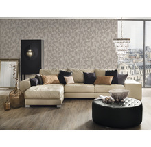 Wohnzimmer mit Sofa, Hocker, Schrank und geometrischer Tapete