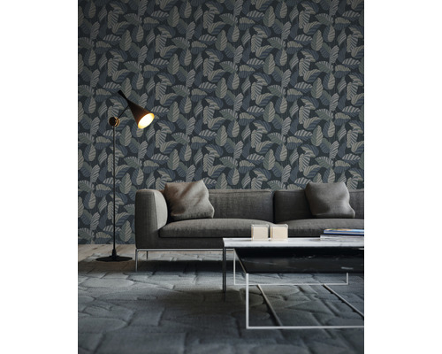 Wohnzimmer mit einer Wandtapete mit Blattmuster hinter einem Sofa
