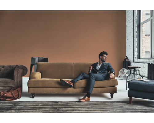 Ein Mann in einem Anzug entspannt sich auf einem Sofa in einem Wohnzimmer.