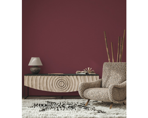 Wohnzimmer mit Sideboard, Lampe, Sessel und Teppich