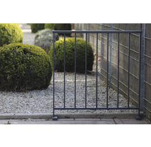 Gartenzaun aus Metall vor Garten mit Sträuchern
