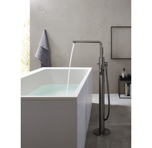 Freistehende Badewanne mit Armatur und fließendem Wasser in einem Badezimmer