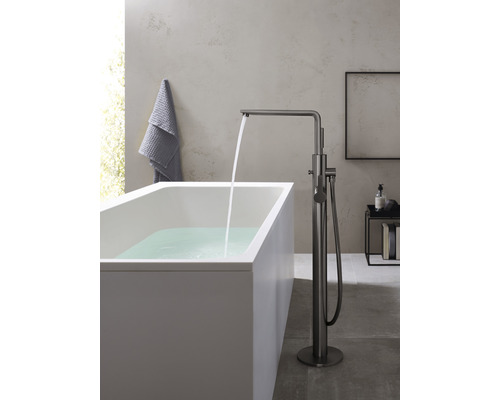 Freistehende Badewanne mit Armatur und fließendem Wasser in einem Badezimmer