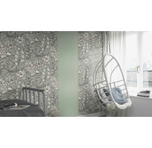 Zimmer mit floral gemusterter Tapete, Bett und Hängesessel