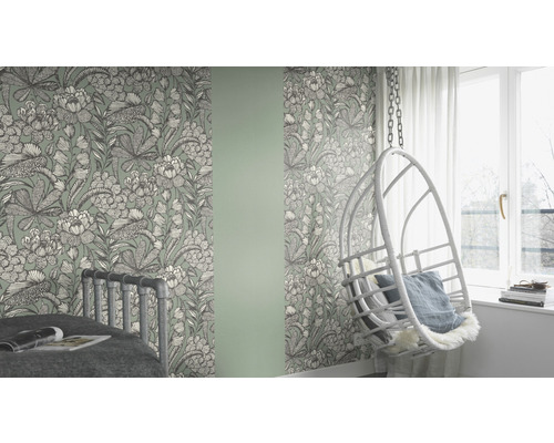 Zimmer mit floral gemusterter Tapete, Bett und Hängesessel