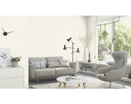 Helles Wohnzimmer mit Sofa, Sessel, Tisch und Dekorationsartikeln