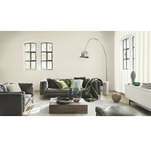 Wohnzimmer mit grauer Ledercouch, Holztisch und dekorativen Elementen.