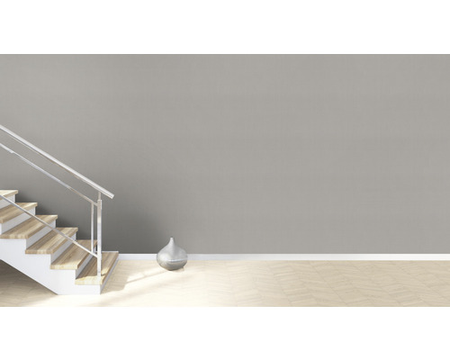 Heller Raum mit Treppe, silberner Vase und Parkettboden.