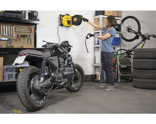 Werkstatt Szene mit Motorrad, Reifenstapel, Werkzeugwand und Wand-Druckluftschlauchaufroller