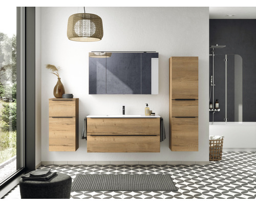 Salle de bains avec lavabo, armoire de toilette et armoire haute aspect bois, baignoire avec paroi de douche et sol à motifs