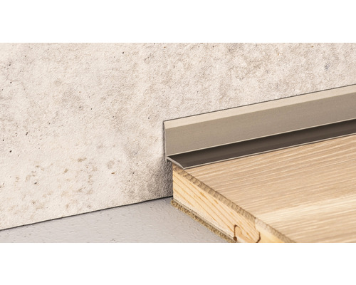 Plinthe métallique entre le mur et le plancher en bois